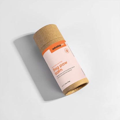 Cylindrical container of dog paw balm with cork lid on a light gray background